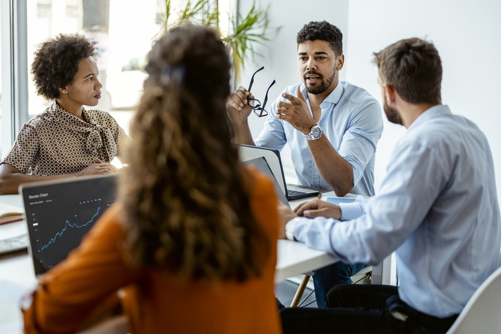 Man leading a meeting with three co-workers